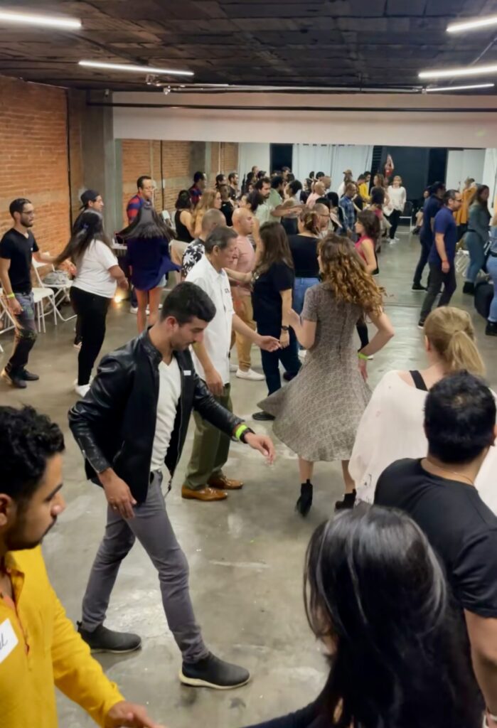 Group of dancers in a Mexico City CDMX Ciudad de México dance studio learning West Coast Swing, smiling and enjoying a lively dance social.