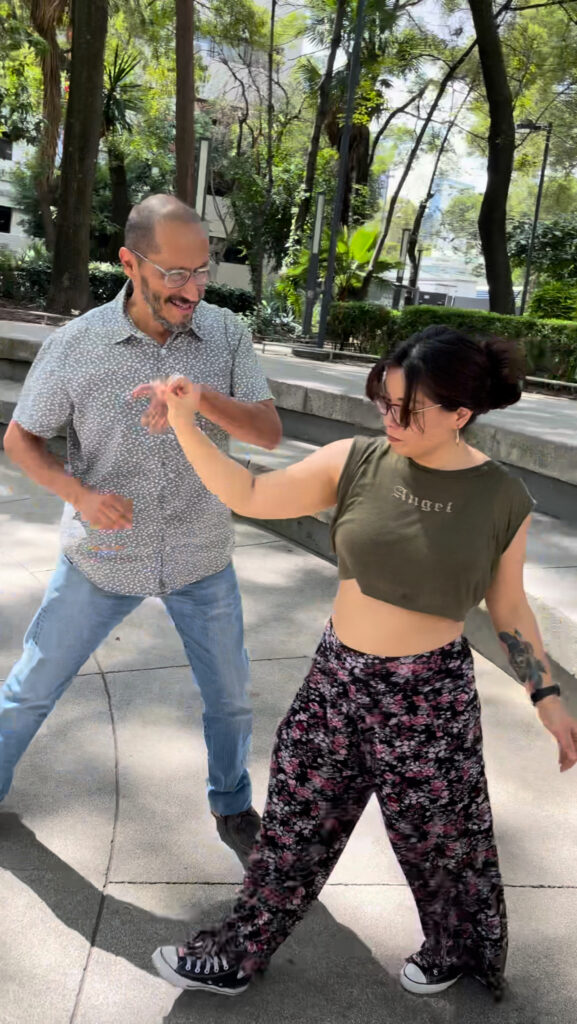 West Coast Swing dancers gracefully moving together in a Mexico City CDMX Ciudad de México plaza, embodying the rhythm and spirit of the dance.